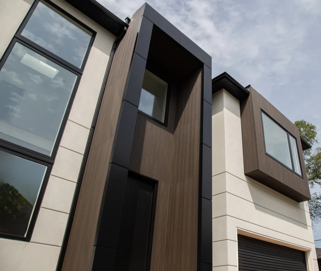 A close-up modern house exterior featuring ACM panels and fluted wood composite panels